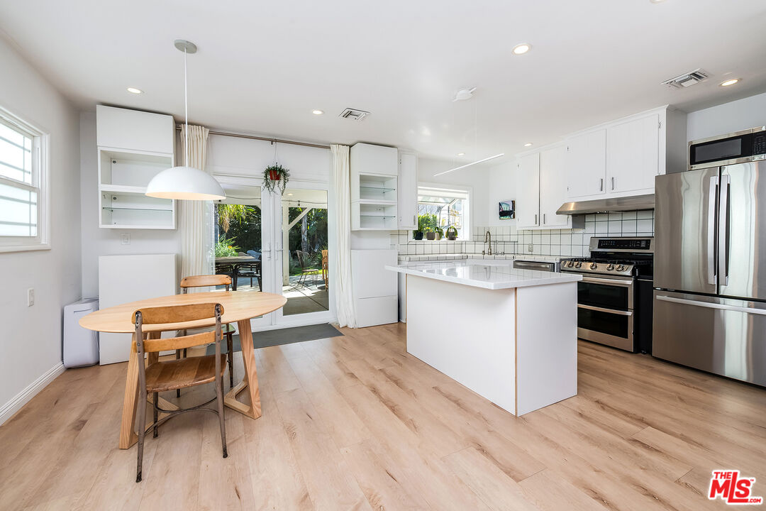 6660 Amigo Avenue Reseda, CA 91335 - Photo 7 of 25 a kitchen with stainless steel appliances kitchen island granite countertop a table chairs and a refrigerator