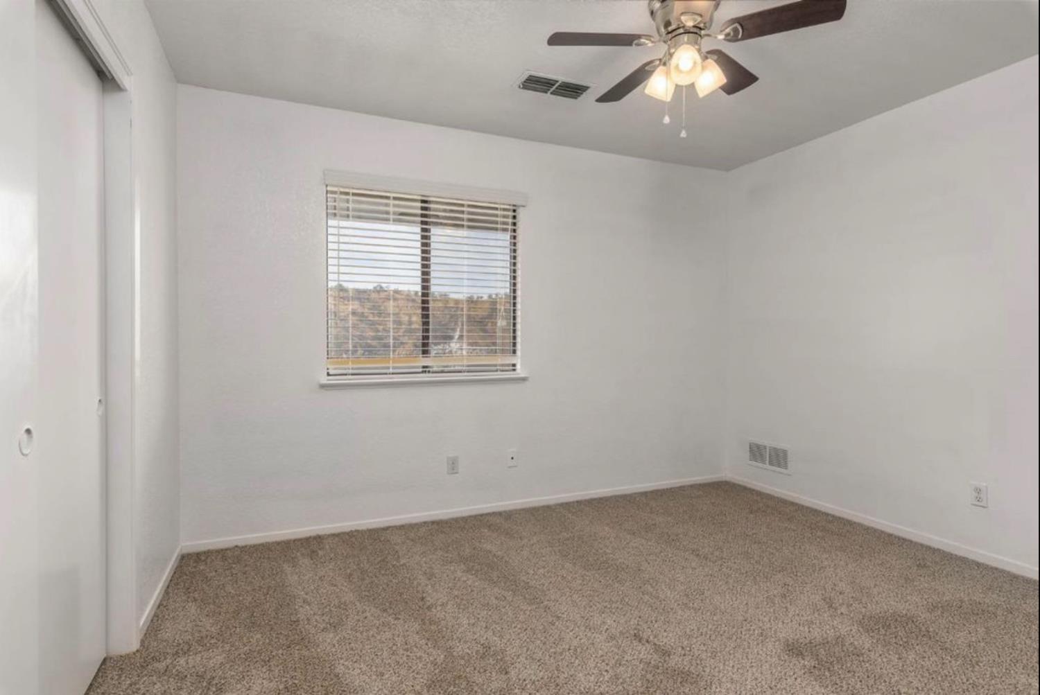 27817 Sky Harbour Road Friant, CA 93626 - Photo 19 of 36 an empty room with a window and a fan
