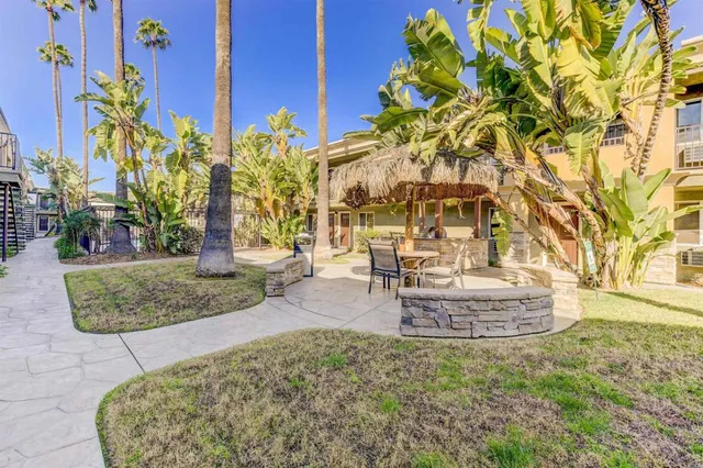 a view of a multi story residential apartment building with a yard