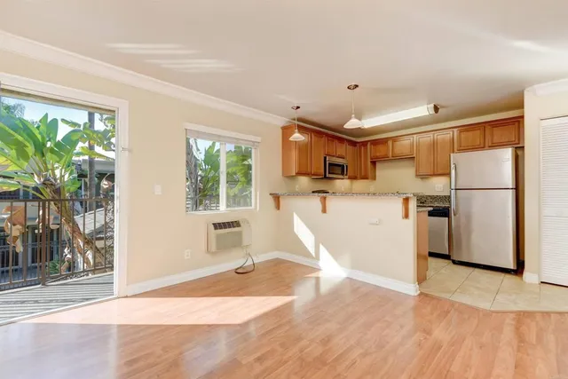a view of a kitchen with wooden floor and a refrigerator