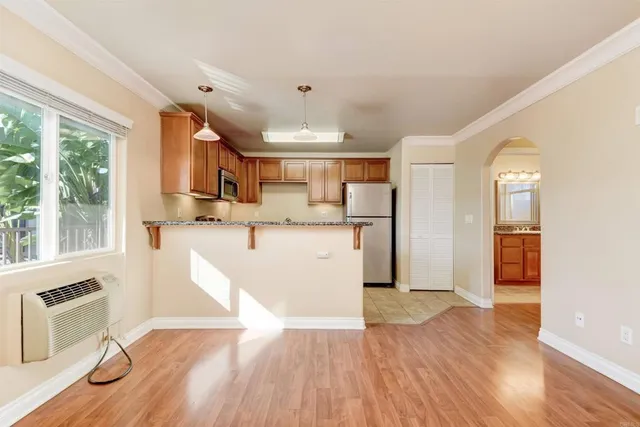 a view of a kitchen with wooden floor and a window