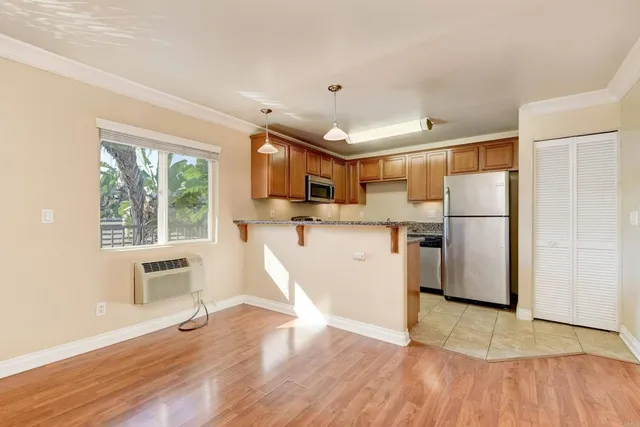 a kitchen with stainless steel appliances a refrigerator a stove a sink dishwasher and a microwave with wooden floor