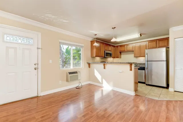 a view of kitchen with stainless steel appliances refrigerator stove and wooden floor
