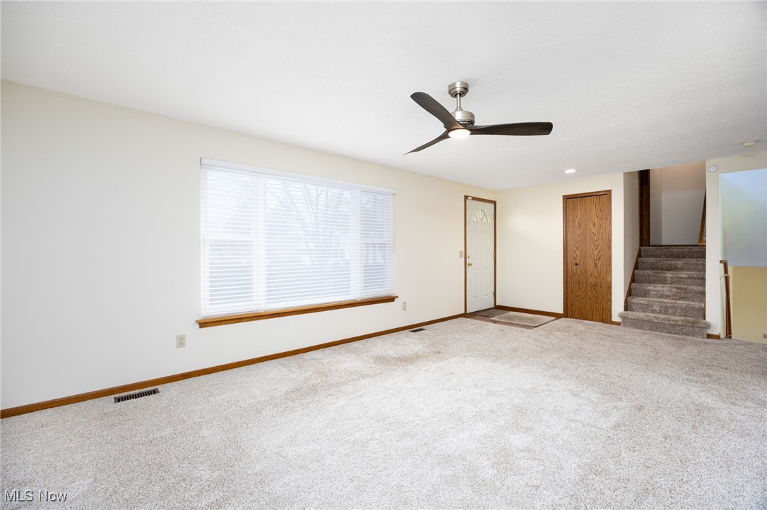 1838 Sandy Lake Road Ravenna, OH 44266 - Photo 12 of 41 Carpeted living room open to staircase to upper and lower levels and dining and kitchen area.