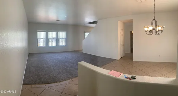 an empty room with windows and chandelier