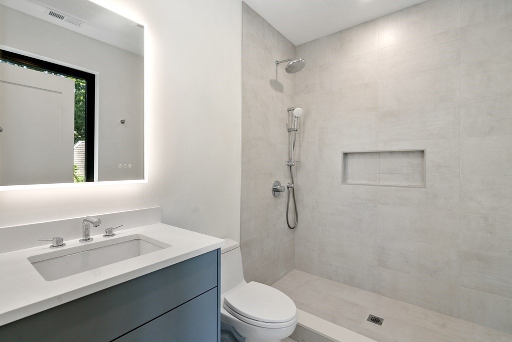 55 Rosalie Road Newton, MA 02459 - Photo 31 of 42 a bathroom with a sink toilet a mirror and shower