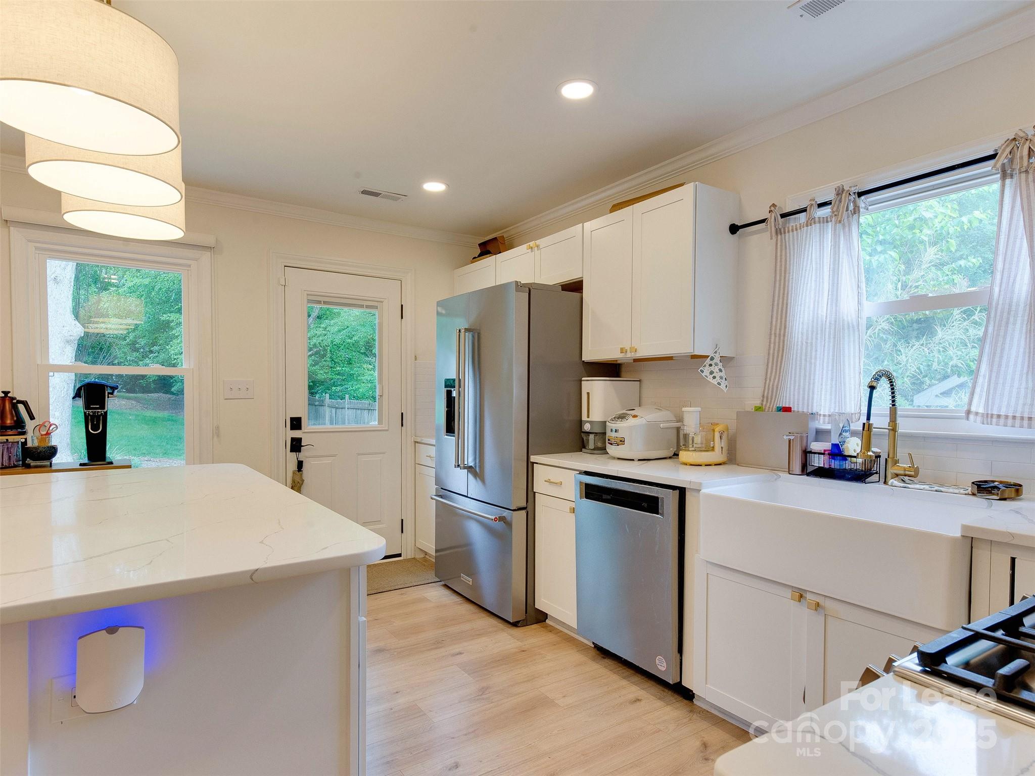 619 Fence Post Lane Matthews, NC 28105 - Photo 14 of 47 a kitchen with a sink a stove a refrigerator cabinets and a window