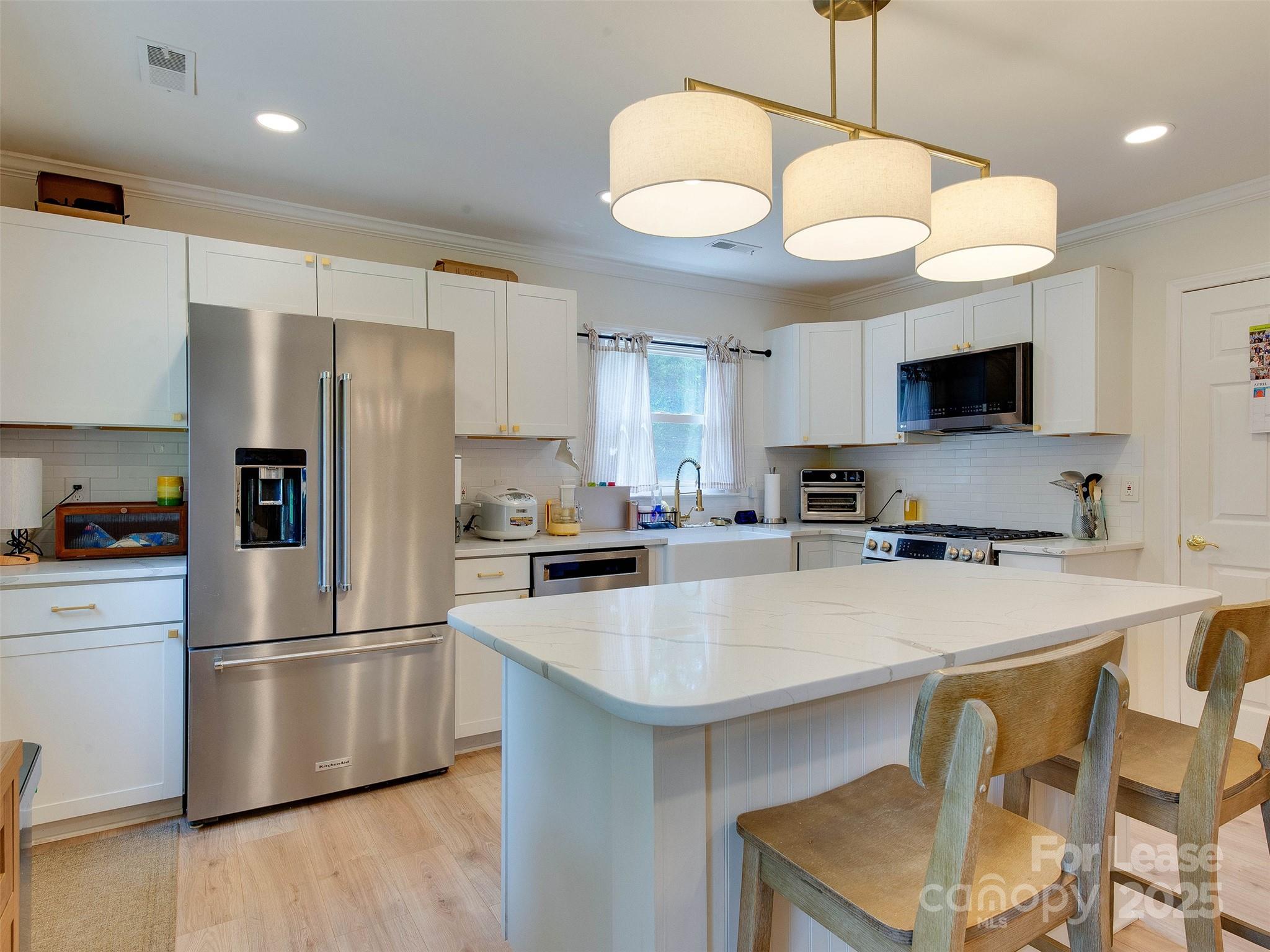 619 Fence Post Lane Matthews, NC 28105 - Photo 16 of 47 a kitchen with a refrigerator a stove top oven a sink dishwasher and a stove with wooden floor