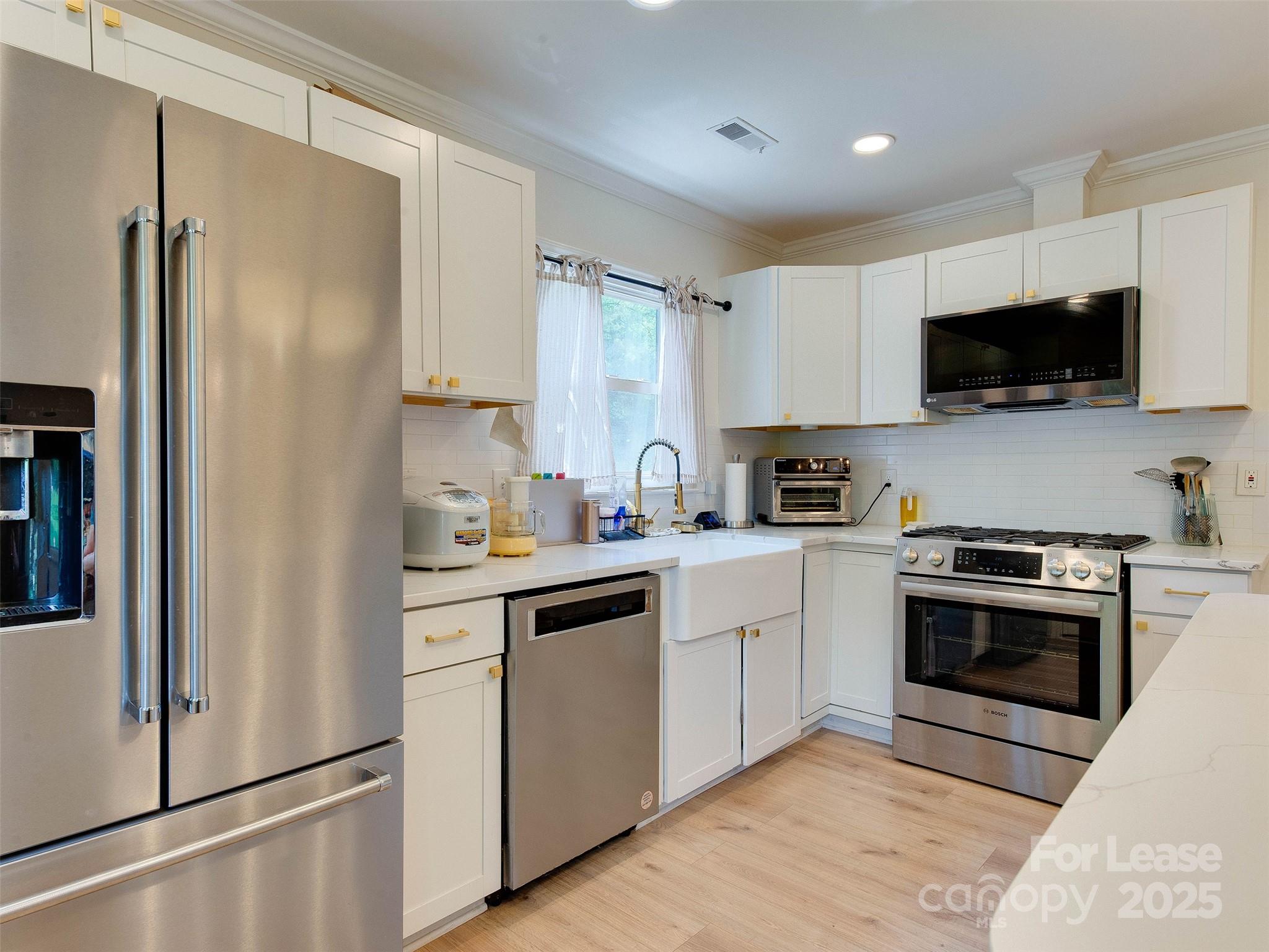 619 Fence Post Lane Matthews, NC 28105 - Photo 17 of 47 a kitchen with cabinets stainless steel appliances and a refrigerator