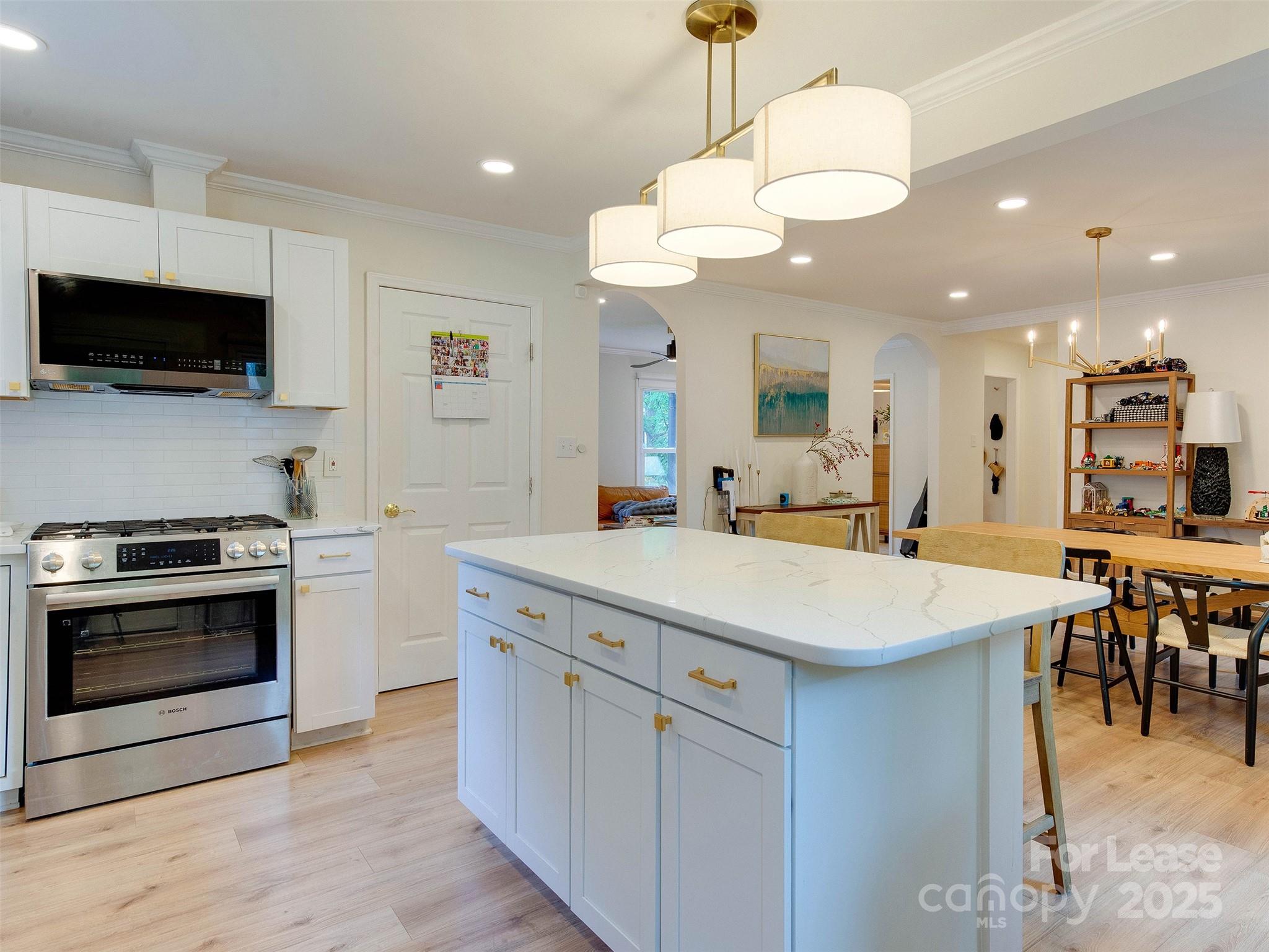 619 Fence Post Lane Matthews, NC 28105 - Photo 20 of 47 a kitchen with kitchen island a sink and a stove top oven with wooden floor