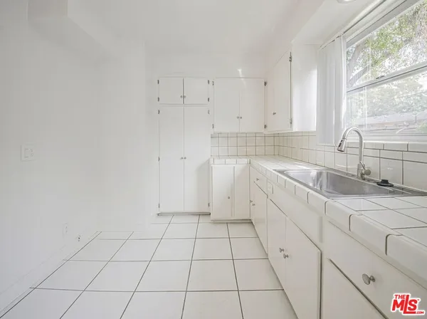 a view of a kitchen with white cabinets