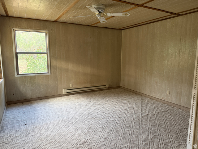 4709 East Independence Road Myton, UT 84052 - Photo 14 of 25 Carpeted room featuring a ceiling fan, wall paneling, and a window