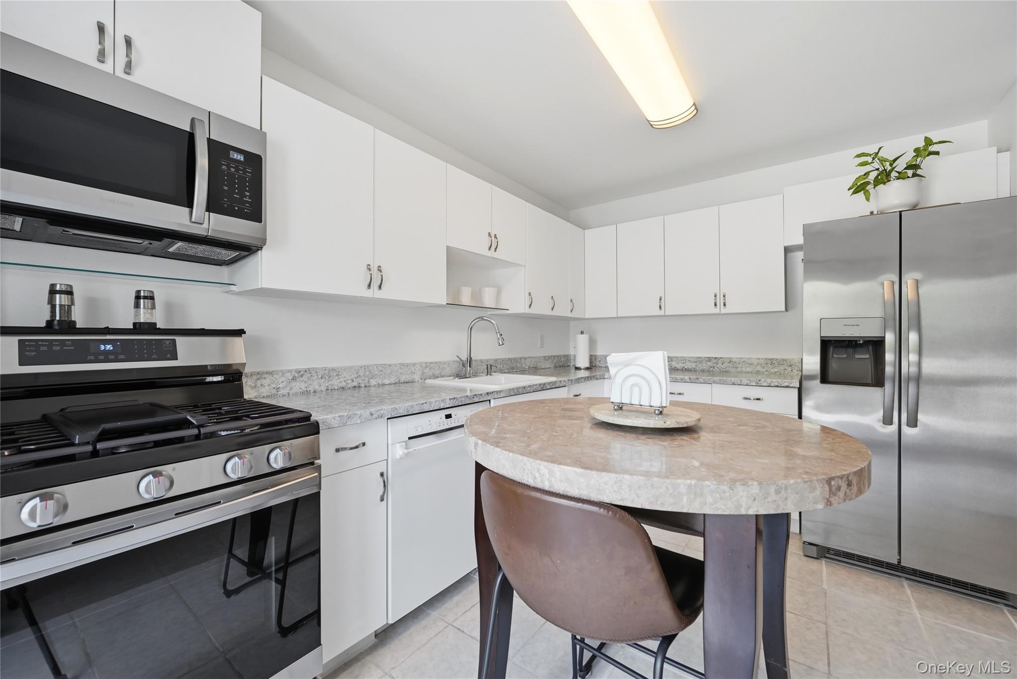 35 Randall Road Shoreham, NY 11786 - Photo 11 of 32 a kitchen with stainless steel appliances granite countertop a stove a sink dishwasher a microwave oven with cabinets and wooden floor