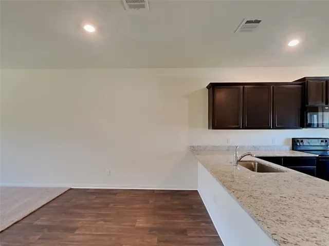 a kitchen with stainless steel appliances a sink a stove a microwave a counter top and cabinets