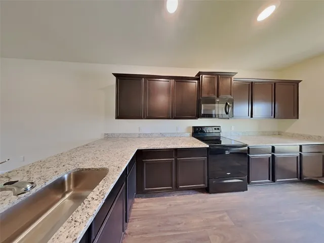 a kitchen with granite countertop a sink and cabinets
