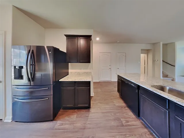 a kitchen with stainless steel appliances granite countertop a refrigerator and a sink