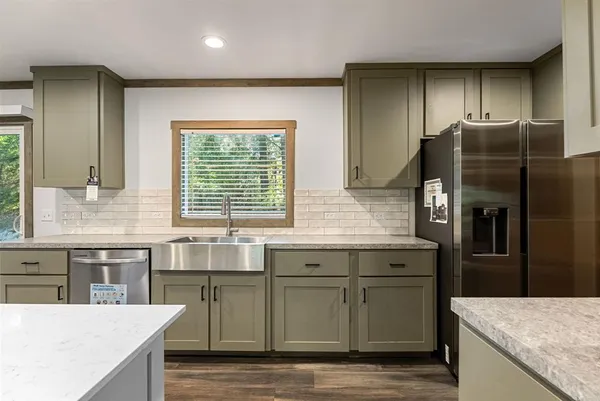 a kitchen with granite countertop a sink and a refrigerator