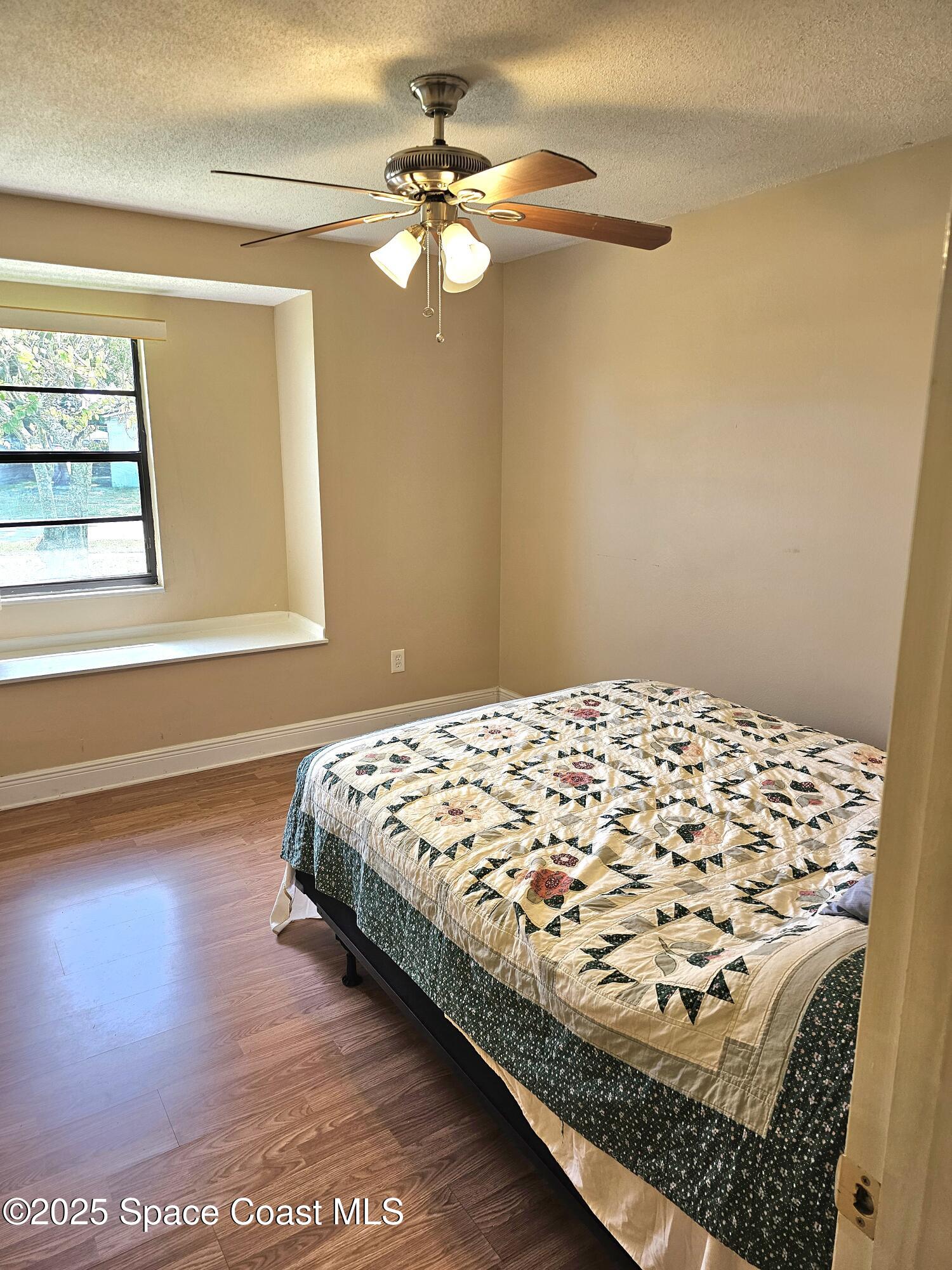 898 Hampton Drive Northeast Palm Bay, FL 32905 - Photo 12 of 20 a bedroom with a bed and a window