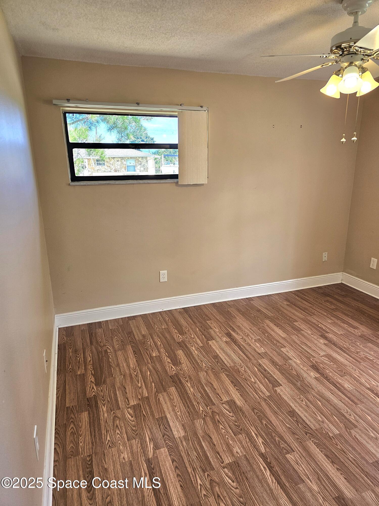 898 Hampton Drive Northeast Palm Bay, FL 32905 - Photo 13 of 20 a view of a room with wooden floor and window