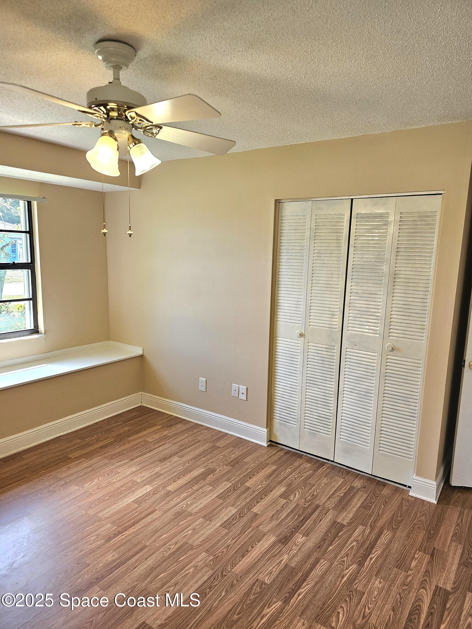 898 Hampton Drive Northeast Palm Bay, FL 32905 - Photo 14 of 20 wooden floor in an empty room with a window