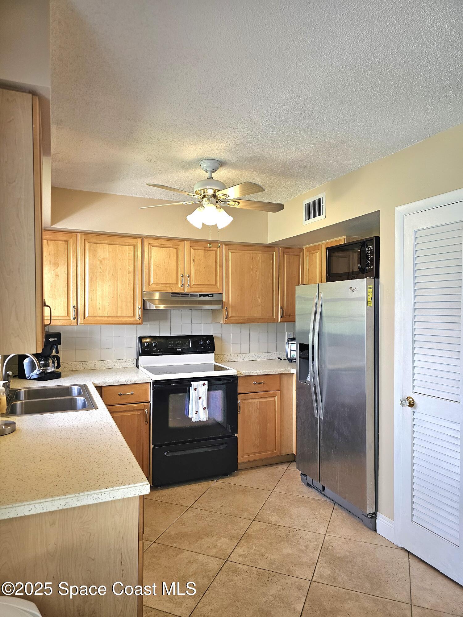 898 Hampton Drive Northeast Palm Bay, FL 32905 - Photo 4 of 20 a kitchen with granite countertop a stove top oven and stainless steel appliances