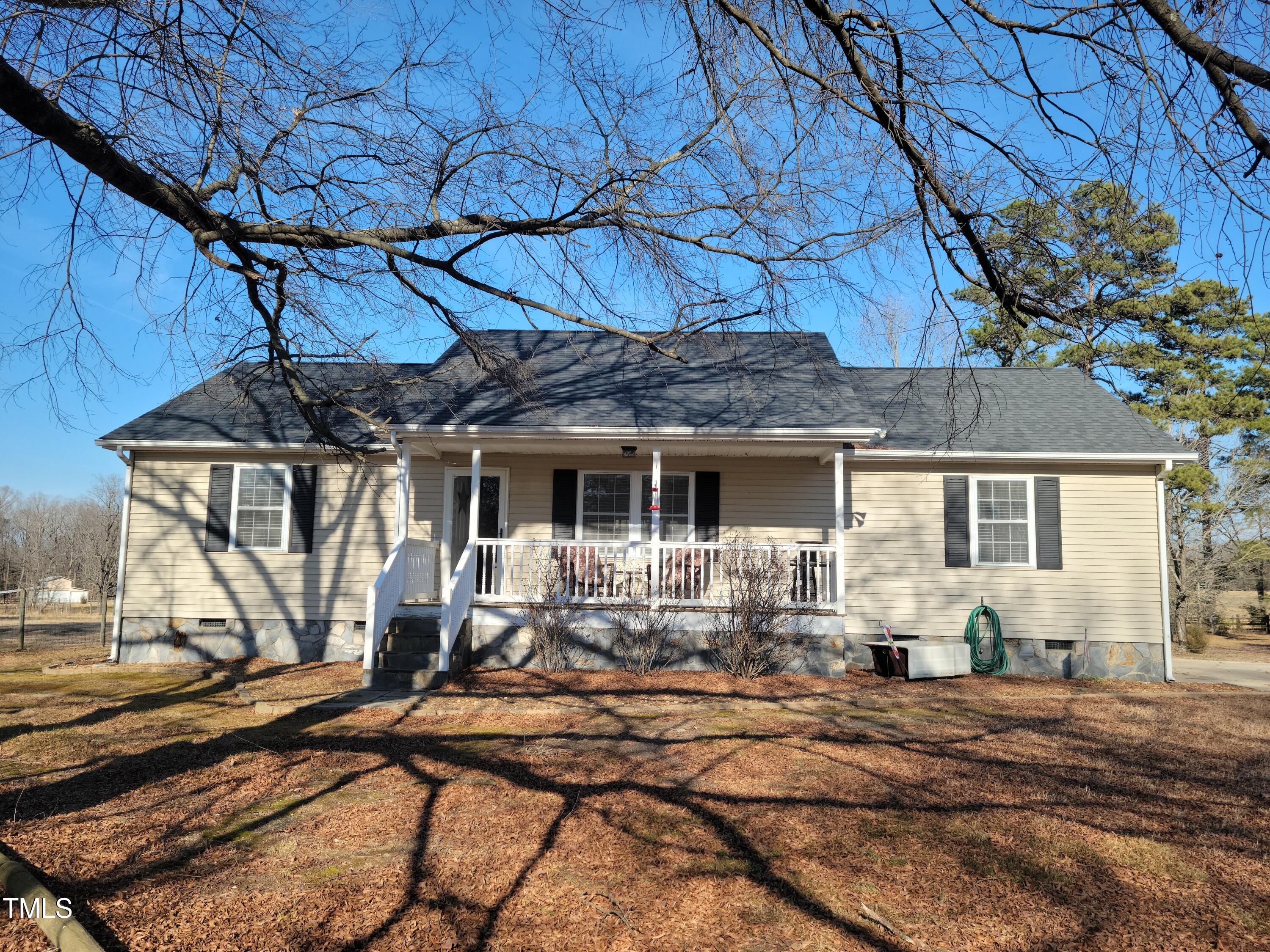 7027 Old 421 Road Julian, NC 27283 - Photo 4 of 72 a front view of a house with basket ball court and a table