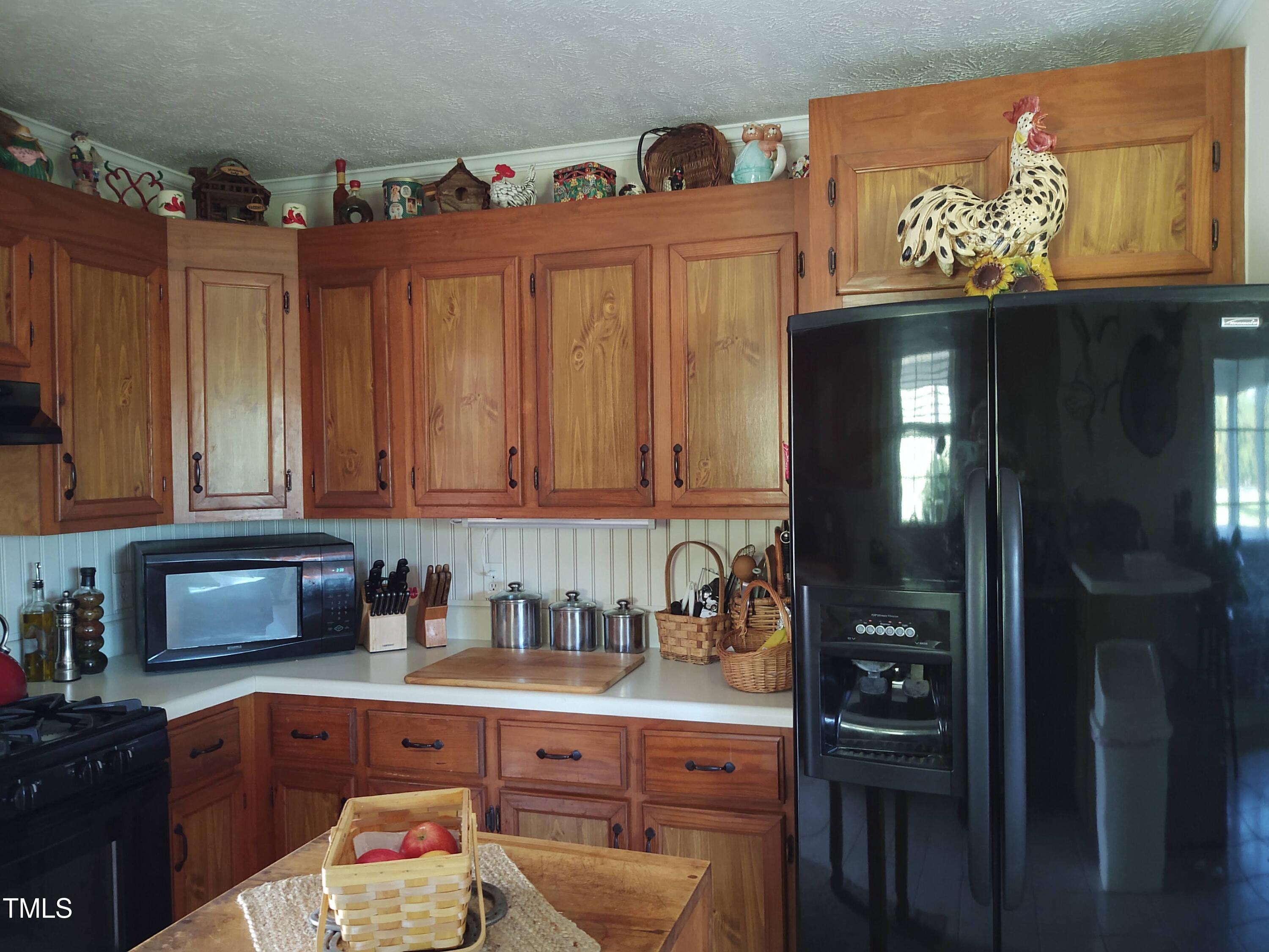 7027 Old 421 Road Julian, NC 27283 - Photo 50 of 72 a kitchen with granite countertop a refrigerator a stove a sink dishwasher and cabinets with wooden floor