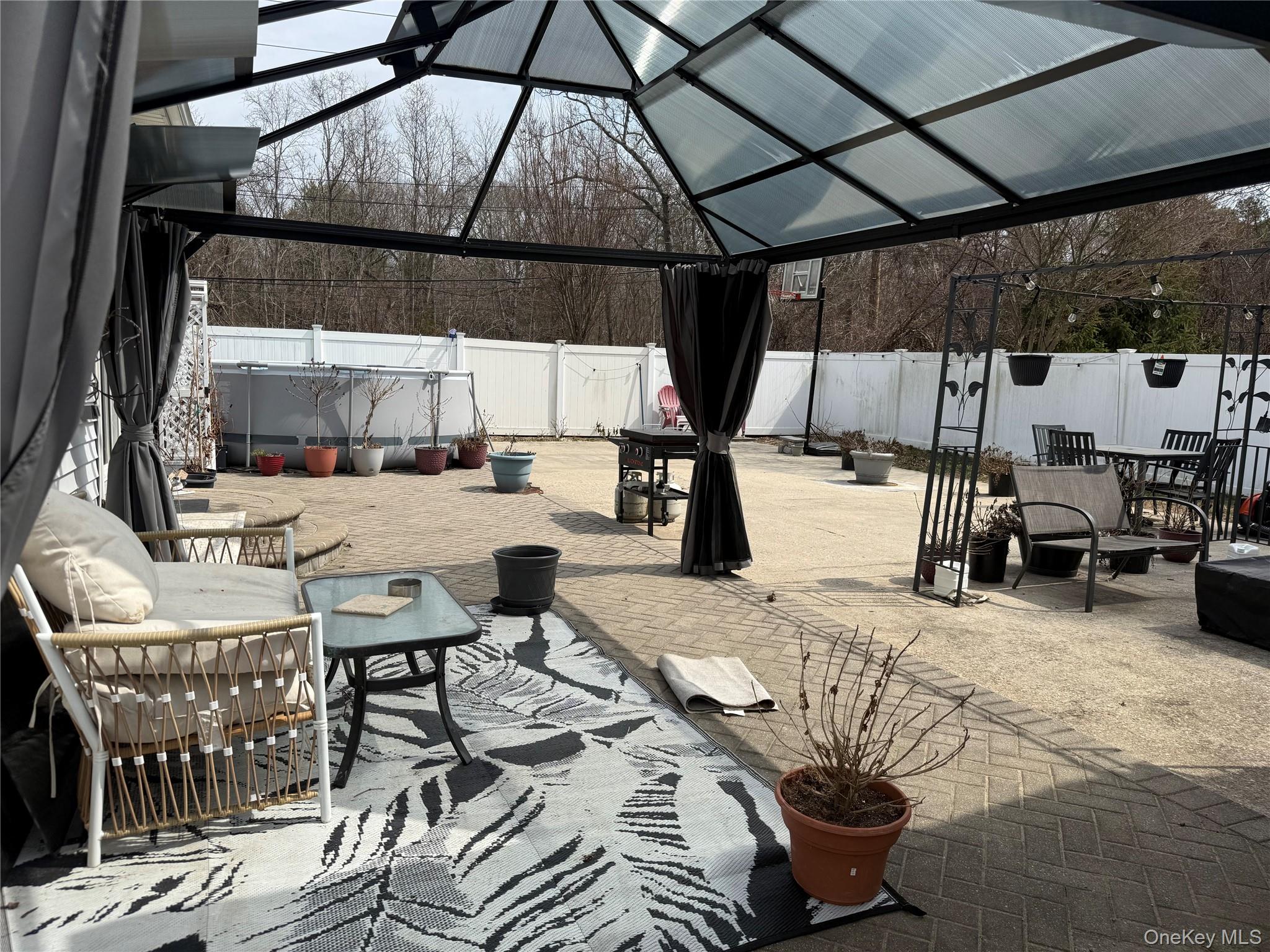 2 1st Street Coram, NY 11727 - Photo 16 of 36 a view of a patio with a table and chairs under an umbrella