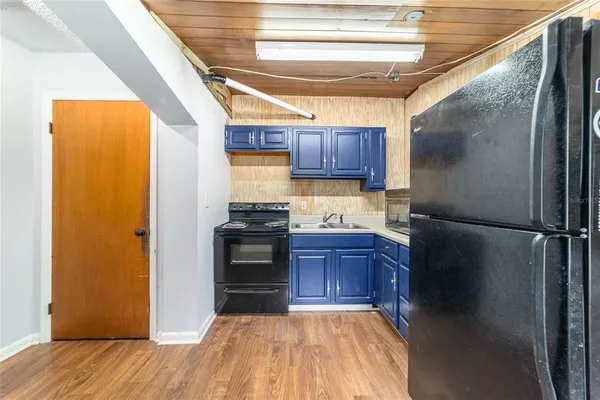 a kitchen with a refrigerator and a wooden floor