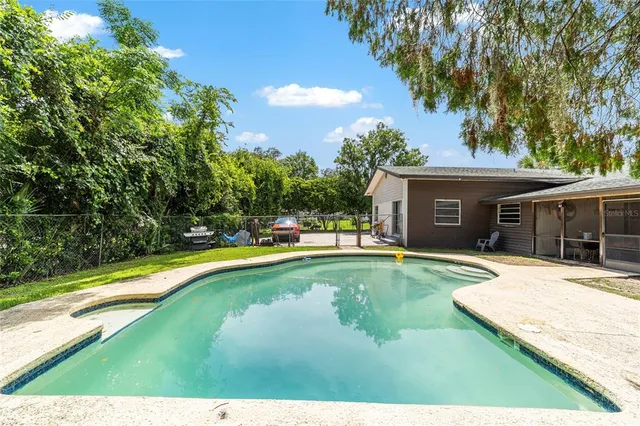 a view of a house with swimming pool and a yard