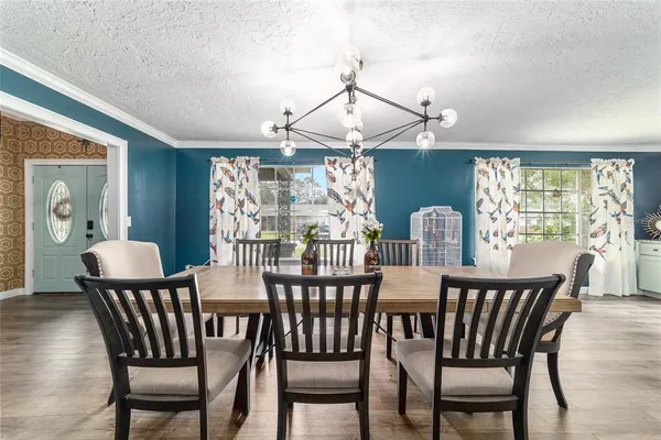 a view of a dining room and livingroom with furniture window and wooden floor