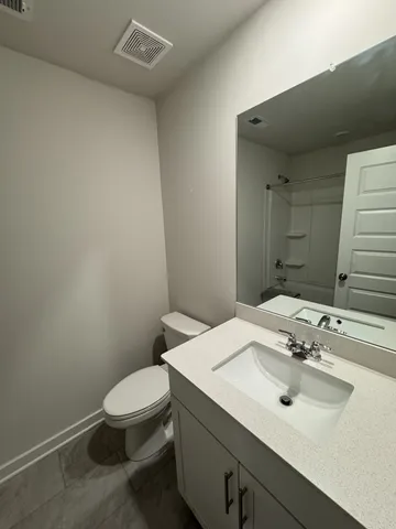 a bathroom with a sink a toilet and mirror