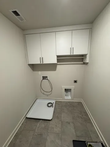 a room with a washing machine and cabinets