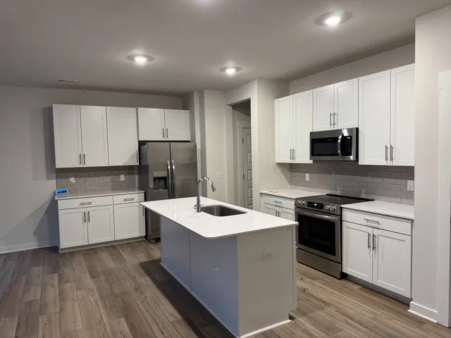 a kitchen with a sink stove top oven and cabinets