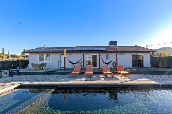 a view of house with swimming pool outdoor seating