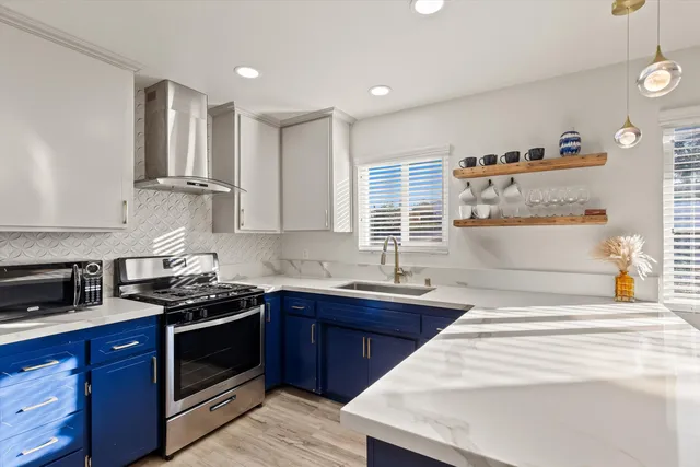 a kitchen with stainless steel appliances granite countertop a sink stove and cabinets