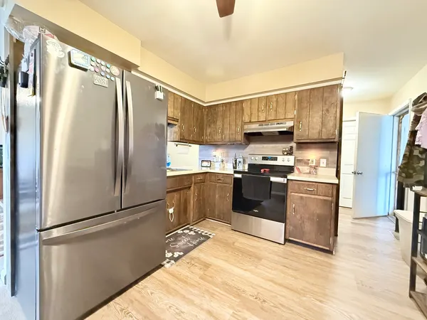 a kitchen with stainless steel appliances granite countertop a refrigerator stove and a sink