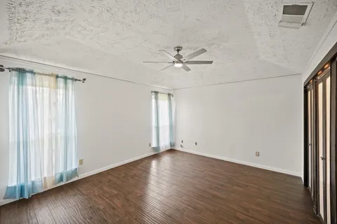 an empty room with wooden floor and window
