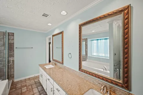a spacious bathroom with a granite countertop sink a mirror and a shower