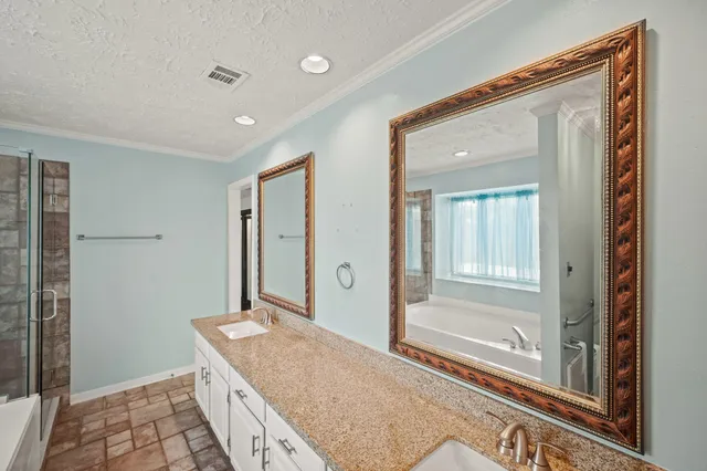 a spacious bathroom with a granite countertop sink a mirror and a shower