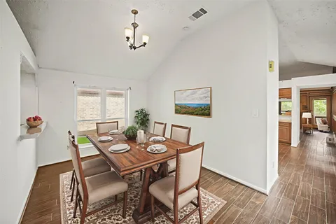 a view of a dining room with furniture wooden floor and a chandelier