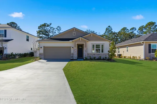 a front view of a house with a garden and yard