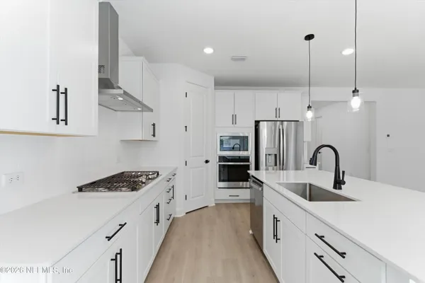 a kitchen with stainless steel appliances a sink a stove and a refrigerator