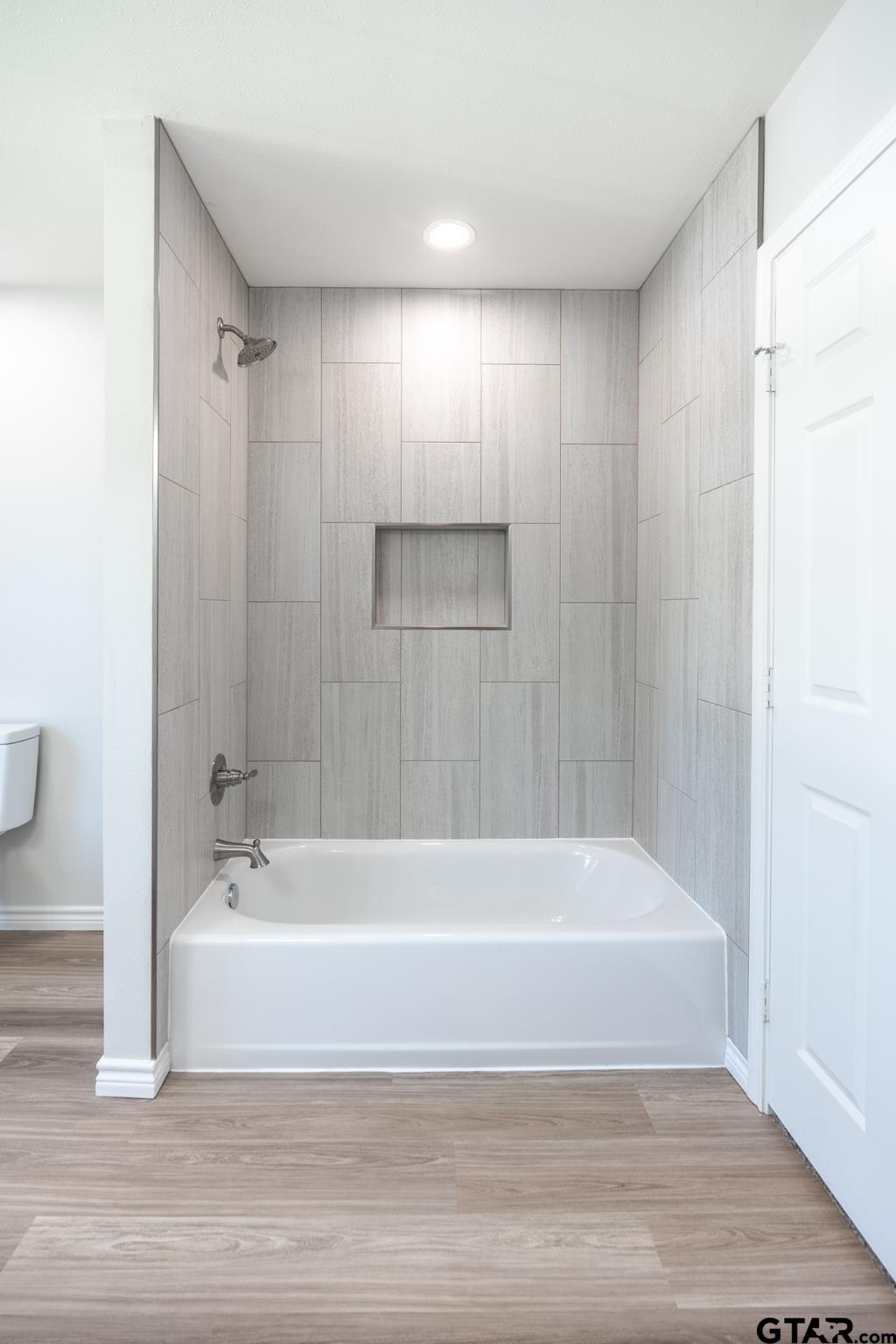 233 Harrison Street Longview, TX 75601 - Photo 31 of 44 a bathroom with a bathtub and a shower