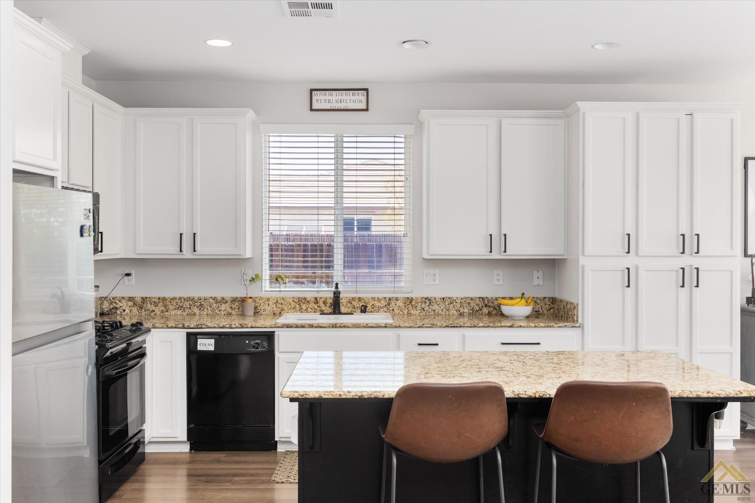 Undisclosed Address Bakersfield, CA 93314 - Photo 13 of 28 a kitchen with granite countertop a sink white cabinets and chairs
