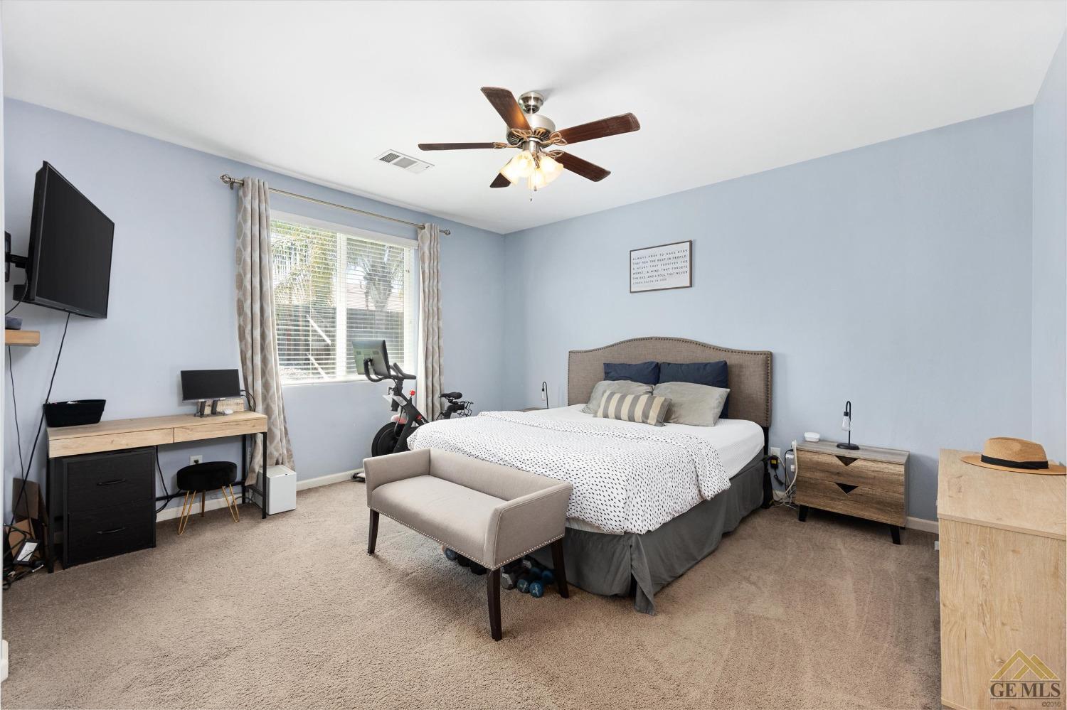 Undisclosed Address Bakersfield, CA 93314 - Photo 17 of 28 a spacious bedroom with a bed and a flat screen tv