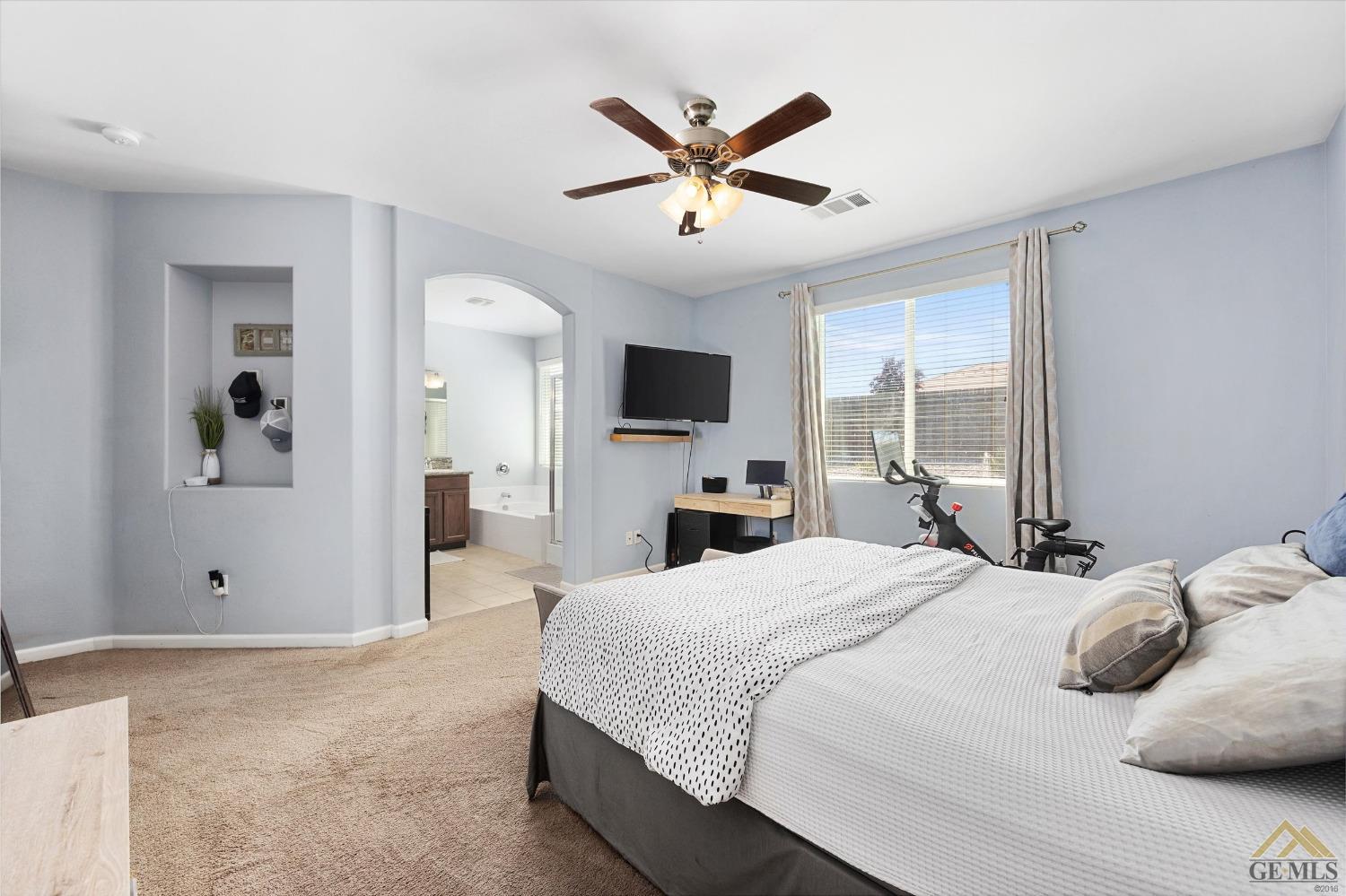 Undisclosed Address Bakersfield, CA 93314 - Photo 18 of 28 a bedroom with a large bed a flat screen tv and a chandelier