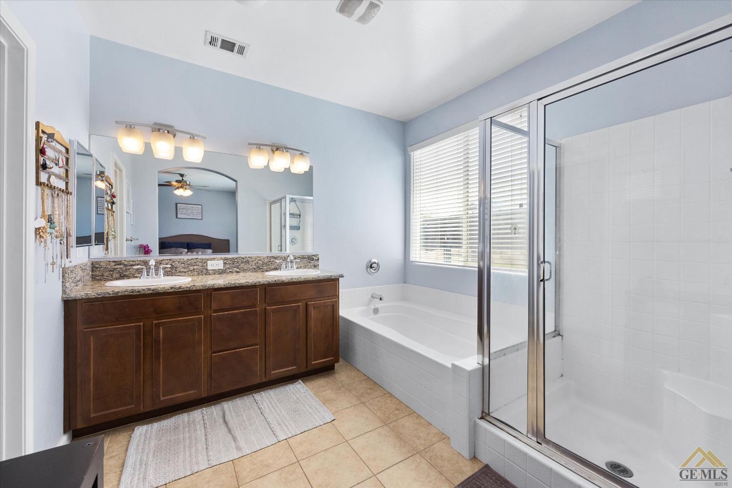 Undisclosed Address Bakersfield, CA 93314 - Photo 19 of 28 a bathroom with a tub sink shower and mirror
