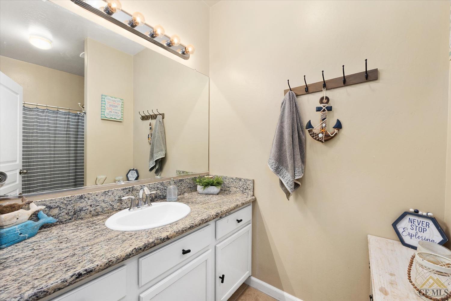 Undisclosed Address Bakersfield, CA 93314 - Photo 23 of 28 a bathroom with a granite countertop sink and a mirror