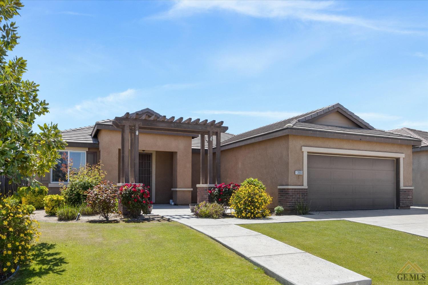 Undisclosed Address Bakersfield, CA 93314 - Photo 3 of 28 a front view of a house with a yard and garage